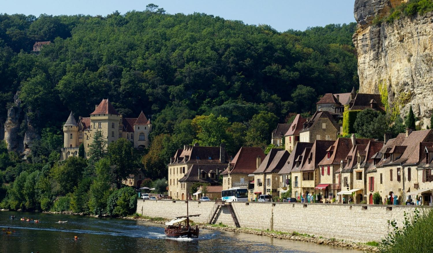The River Dordogne, where residents and travellers gather for communal dinners, pétanque tournaments, and twilight concerts. (Credit: Paola Capelletto)