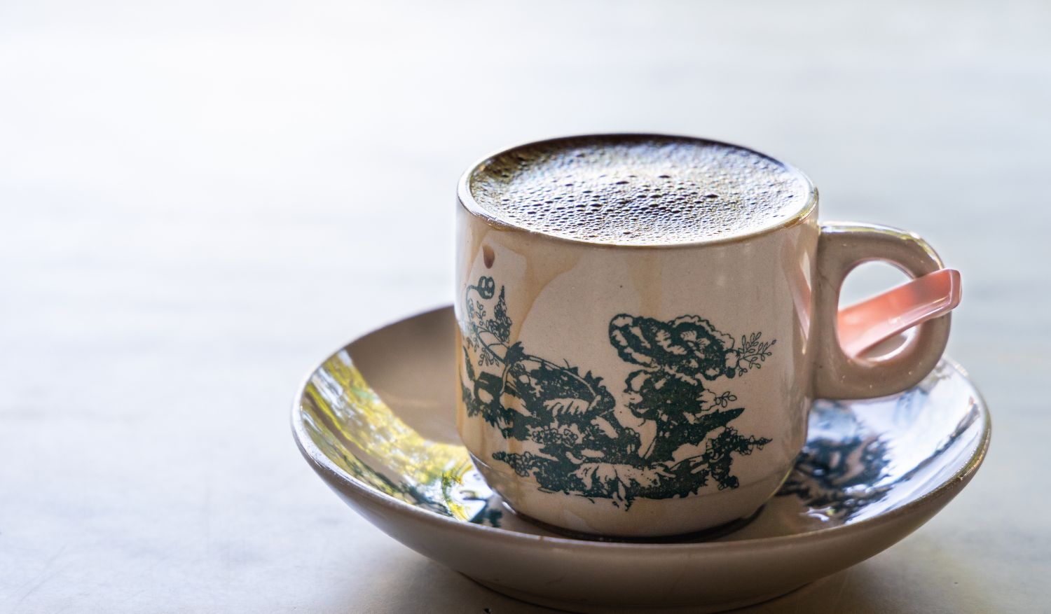 Aromatic frothy coffee served in a traditional Chinese cup and saucer in a kopitiam.